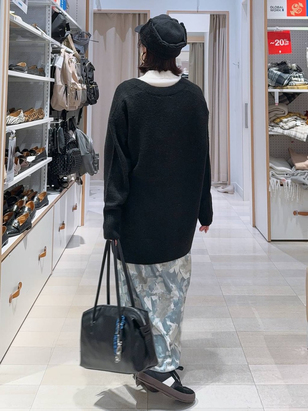 ブラック系のスニーカー、ブラック系のボストンバッグ、ホワイト系のニット/セーターを着用したレディースの冬コーディネートの5枚目の写真