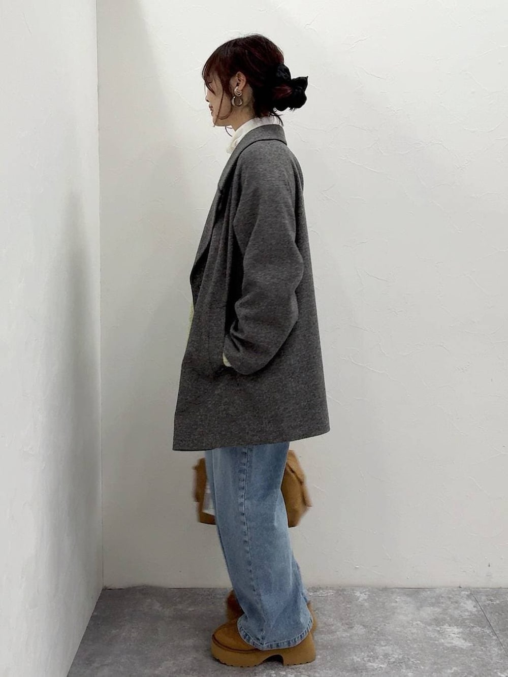 ベージュ系のボストンバッグ、グレー系のチェスターコート、イエロー系のブーツを着用したレディースの冬コーディネートの6枚目の写真