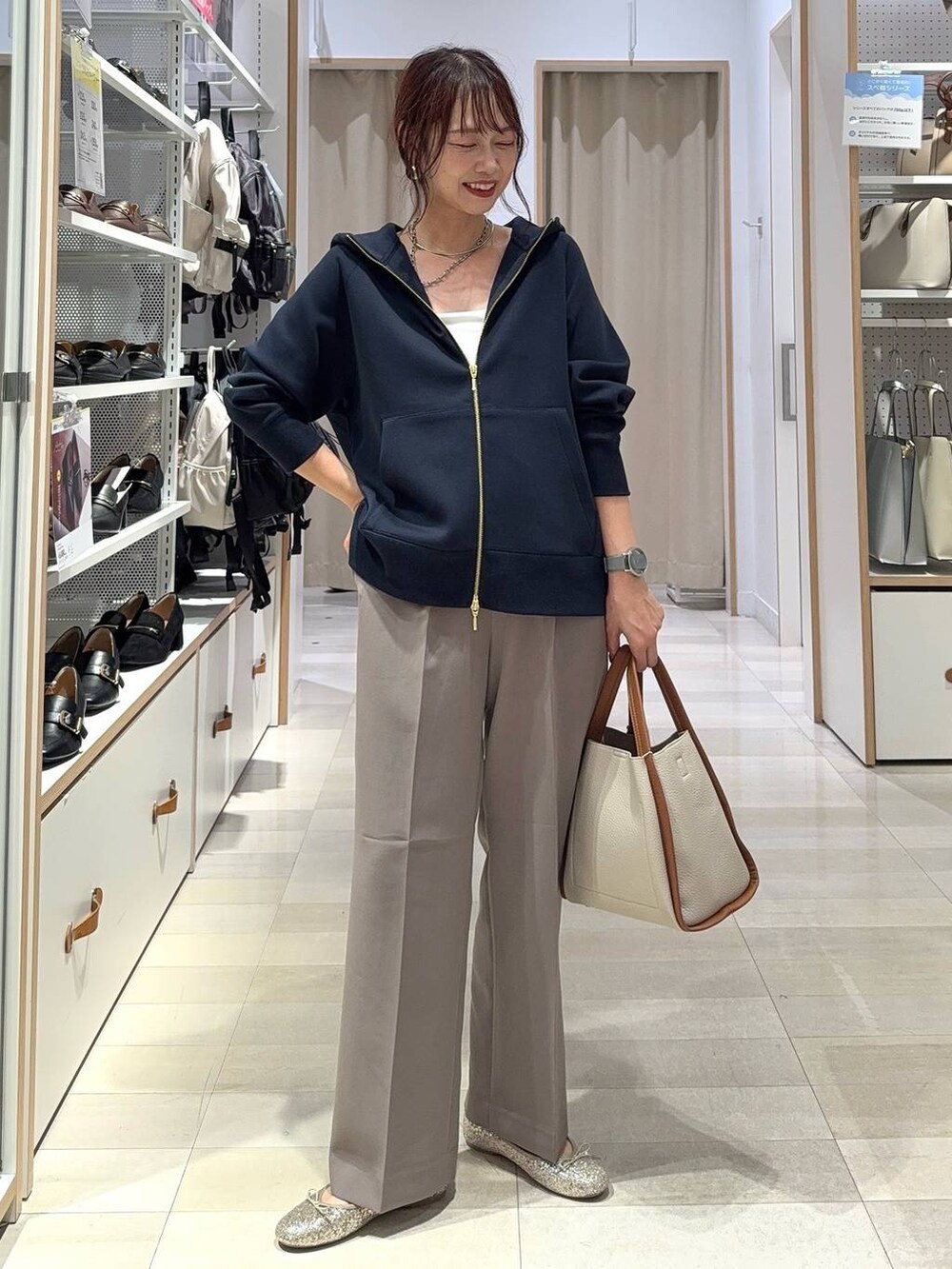 ブラック系のスニーカー、ブラック系のスカート、ホワイト系のTシャツ/カットソーを着用したレディースの秋コーディネートの2枚目の写真