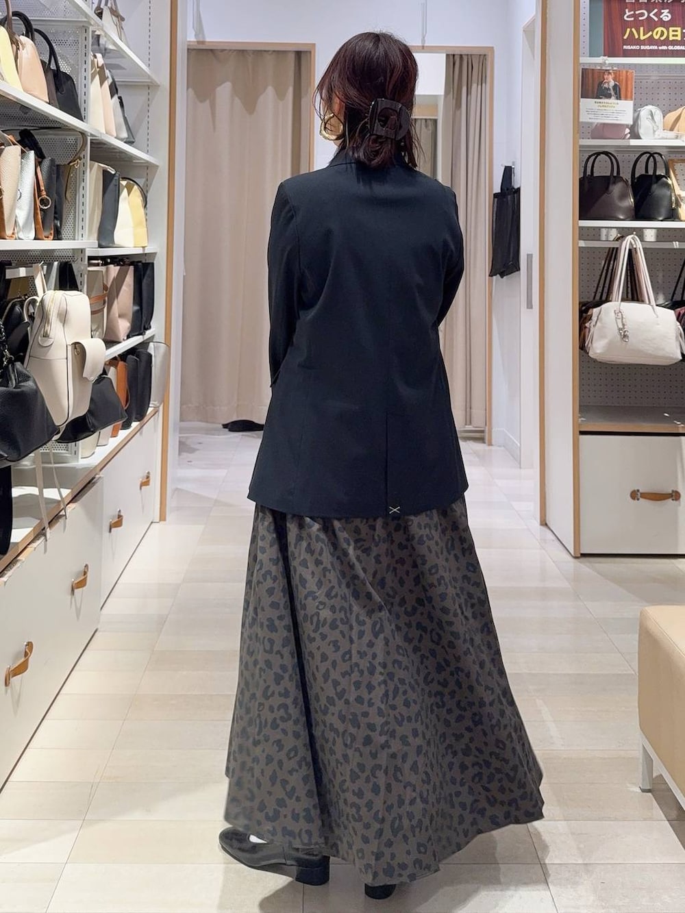 ブラウン系のショルダーバッグ、ブルー系のテーラードジャケット、その他のスカートを着用したレディースの冬コーディネートの6枚目の写真