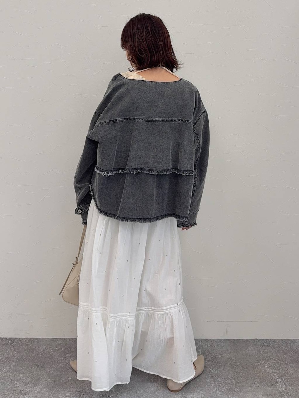 ホワイト系のパンプス、ベージュ系のショルダーバッグ、シルバー系のネックレスを着用したレディースの春コーディネートの5枚目の写真