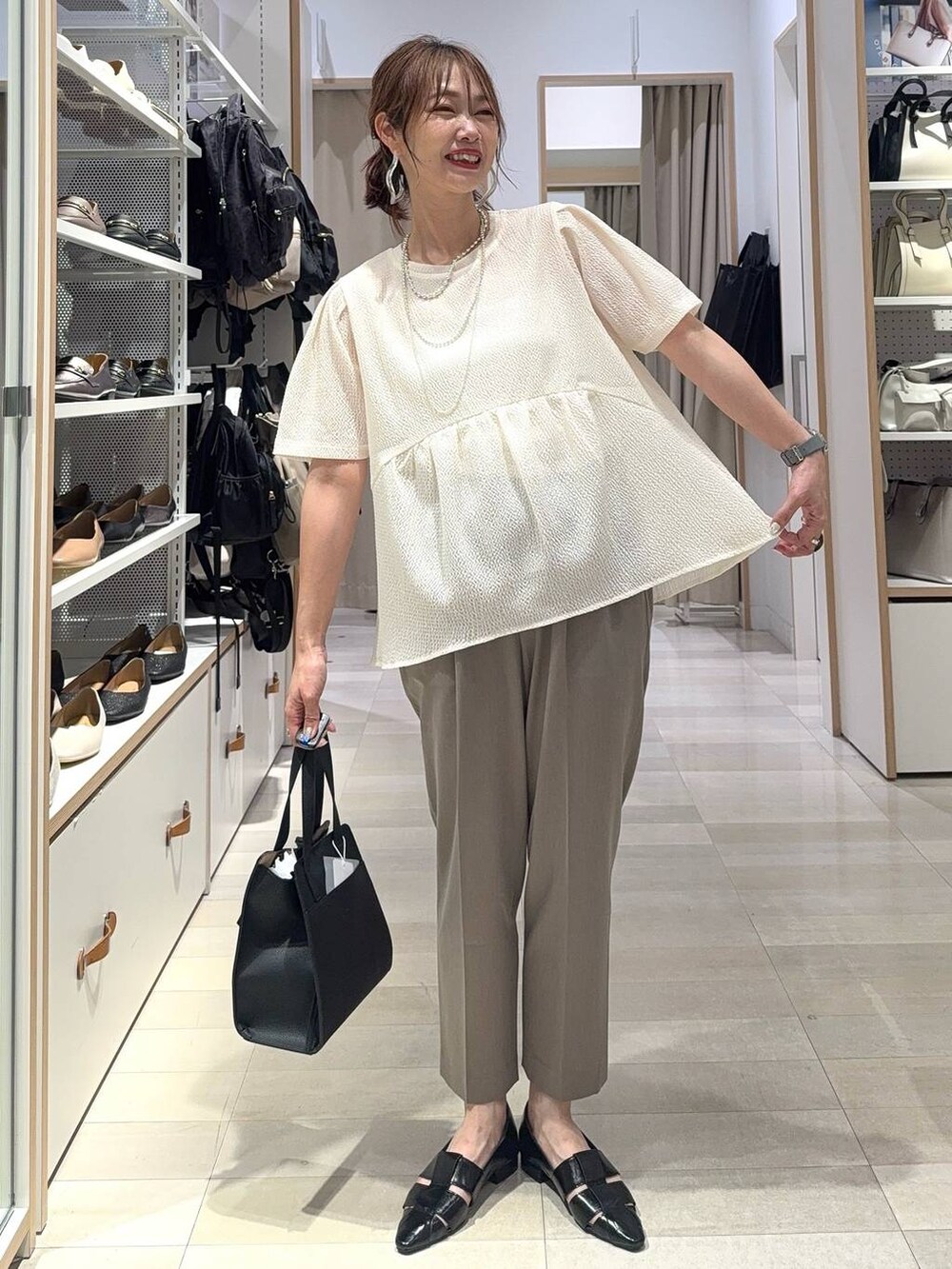 ブルー系のデニムパンツ、グレー系のボストンバッグ、ブラック系のカーディガン/ボレロを着用したレディースの夏コーディネートの5枚目の写真