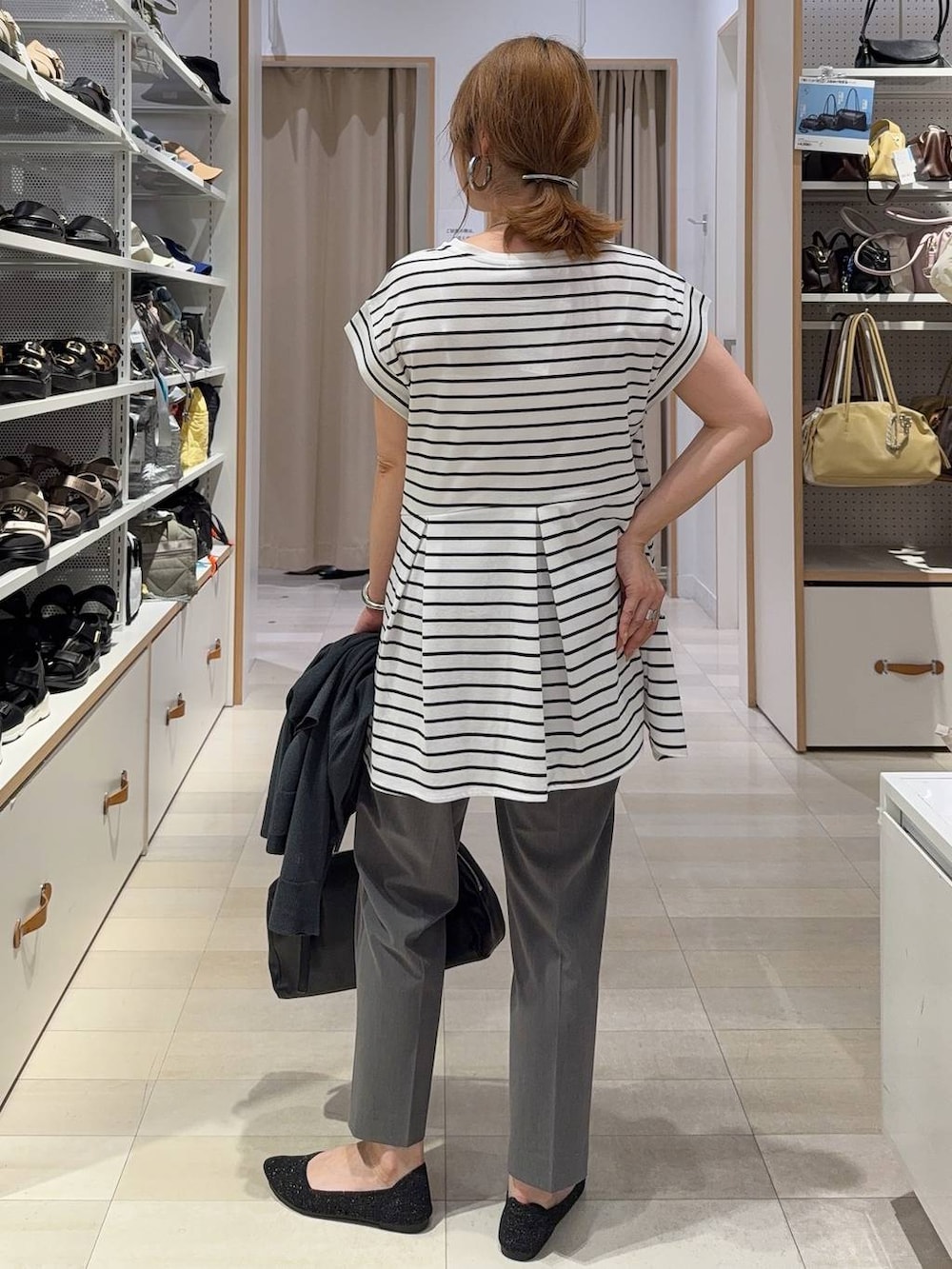 グレー系のその他パンツ、ブラック系のショルダーバッグ、ホワイト系のTシャツ/カットソーを着用したレディースの春コーディネートの8枚目の写真