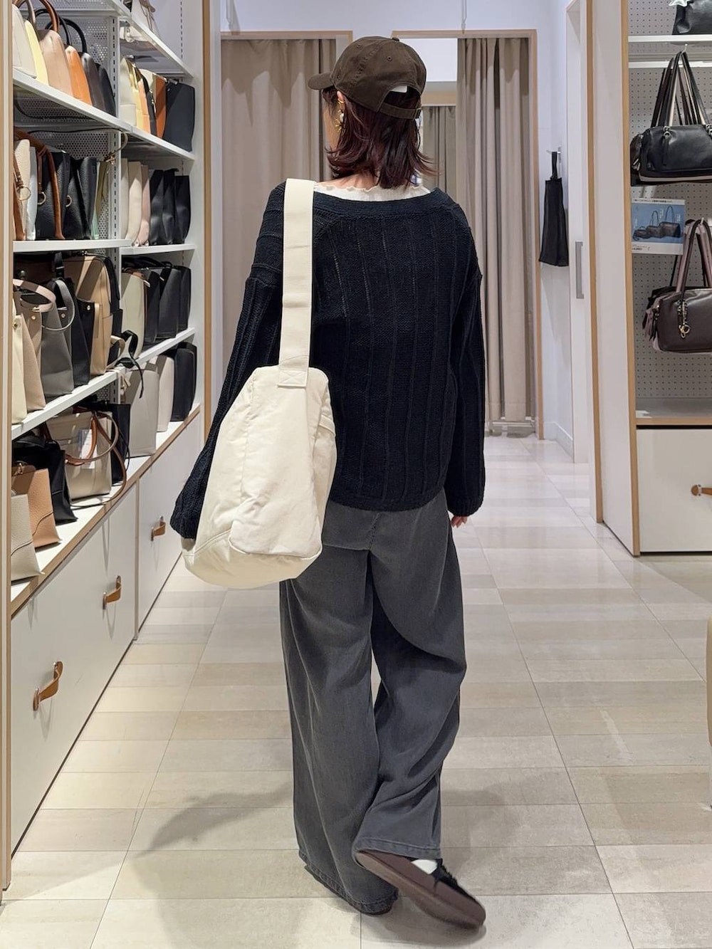 ブラック系のスニーカー、ベージュ系のショルダーバッグ、ホワイト系のTシャツ/カットソーを着用したレディースの春コーディネートの4枚目の写真