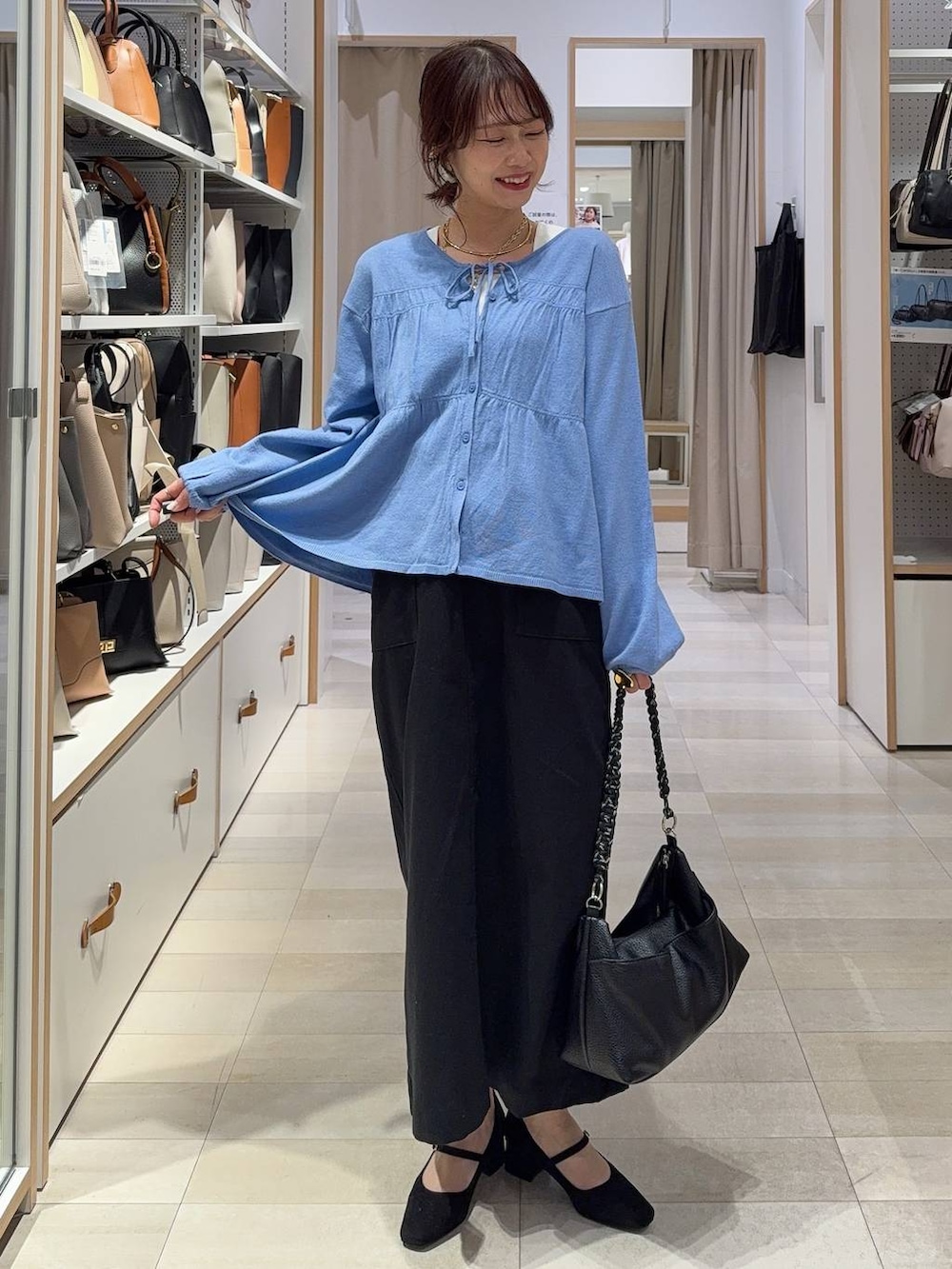 グレー系のスニーカー、ブラック系のバックパック/リュック、ブラック系のスカートを着用したレディースの春コーディネートの2枚目の写真