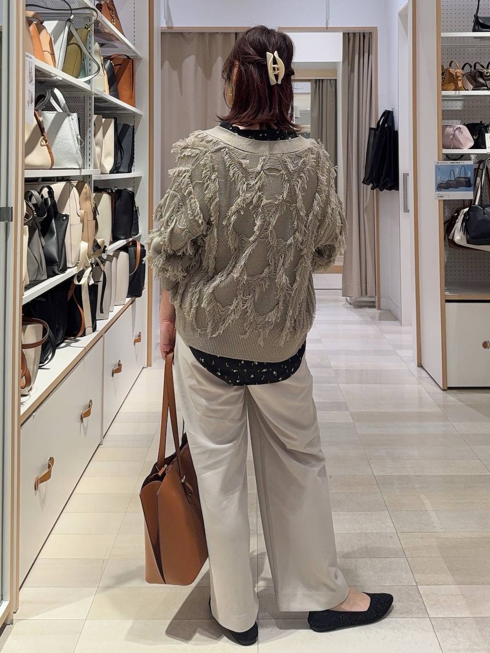 ブラック系のシャツ/ブラウス、ブラウン系のトートバッグ、ブラック系のパンプスを着用したレディースの春コーディネートの5枚目の写真