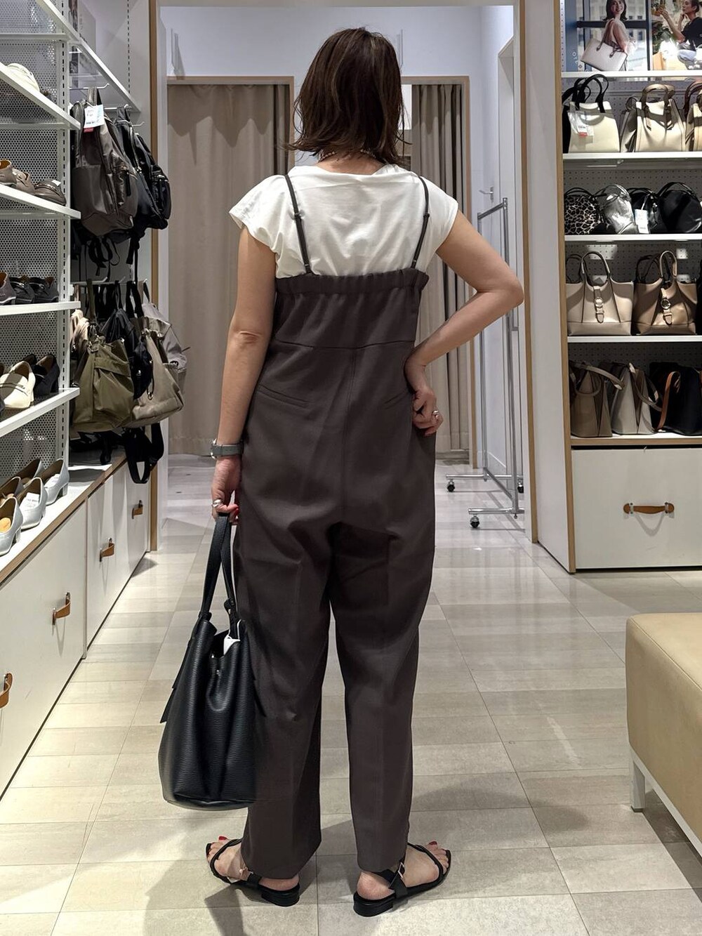 ブルー系のデニムパンツ、ブラック系のトートバッグ、グリーン系のTシャツ/カットソーを着用したレディースの春コーディネートの9枚目の写真