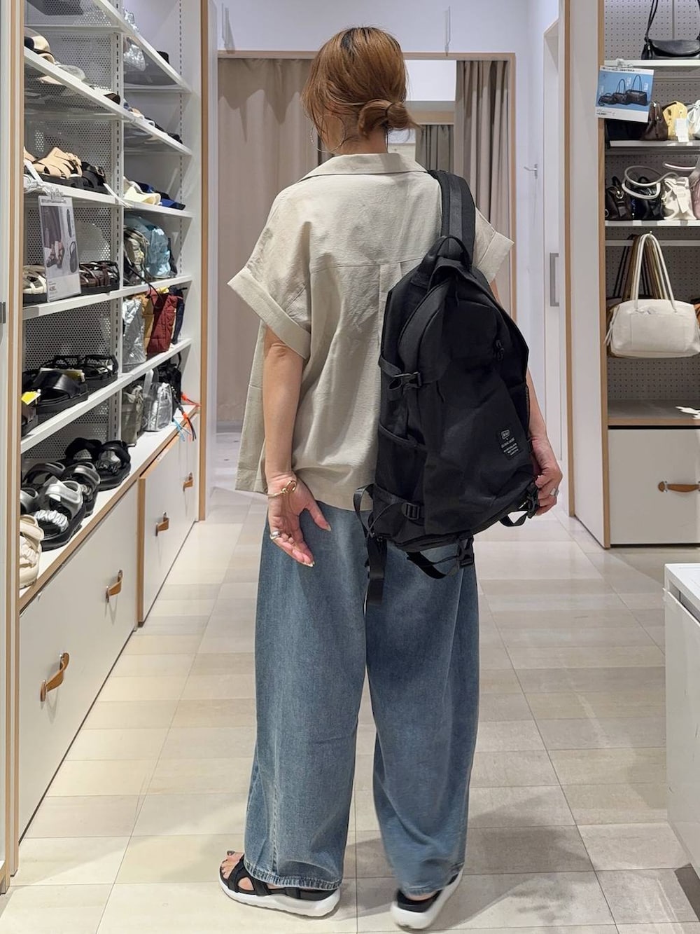 ブルー系のデニムパンツ、ブラウン系のタンクトップ、ベージュ系のシャツ/ブラウスを着用したレディースの夏コーディネートの4枚目の写真