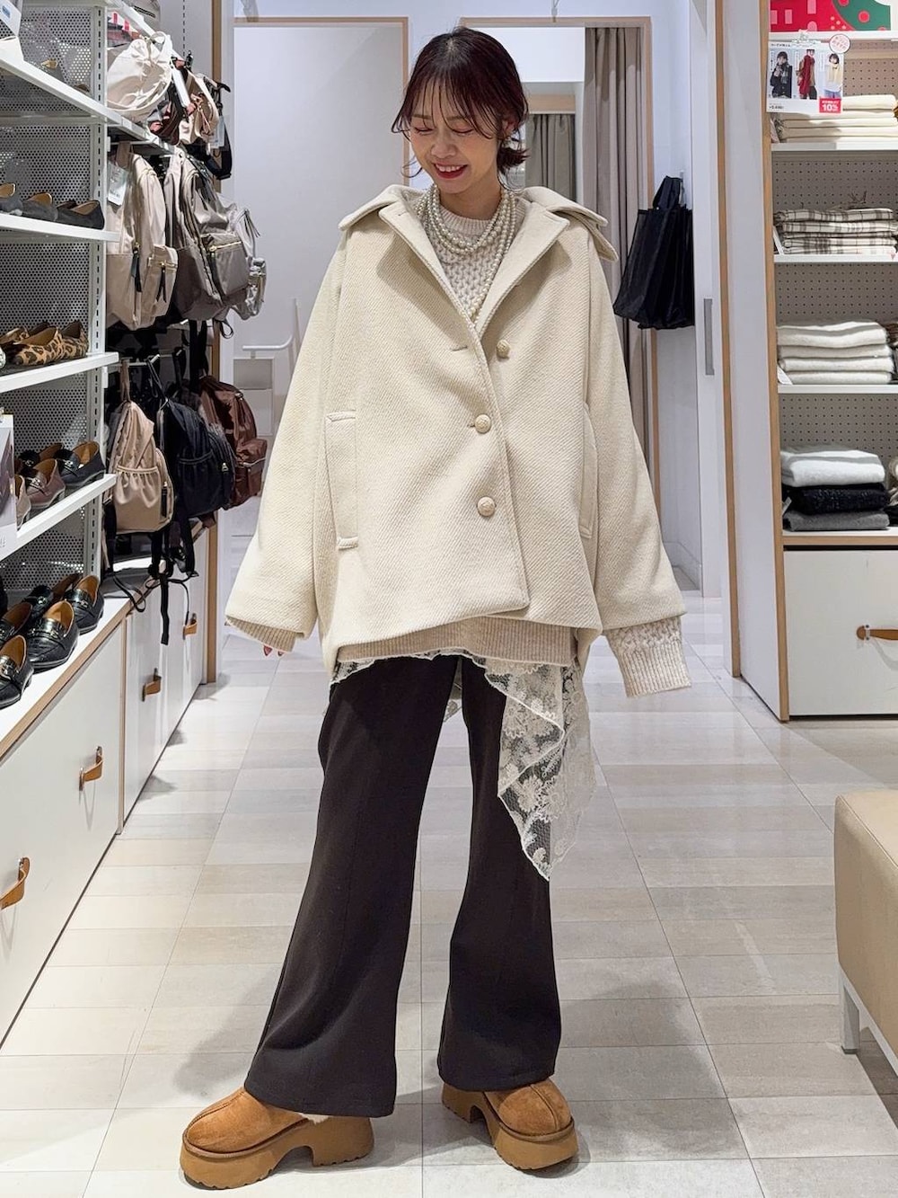 ブラック系のショルダーバッグ、イエロー系のブーツ、ホワイト系のニット/セーターを着用したレディースの冬コーディネートの3枚目の写真