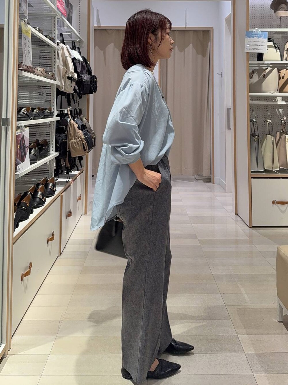 ブラック系のパンプス、グレー系のその他パンツ、ブルー系のシャツ/ブラウスを着用したレディースの秋コーディネートの4枚目の写真