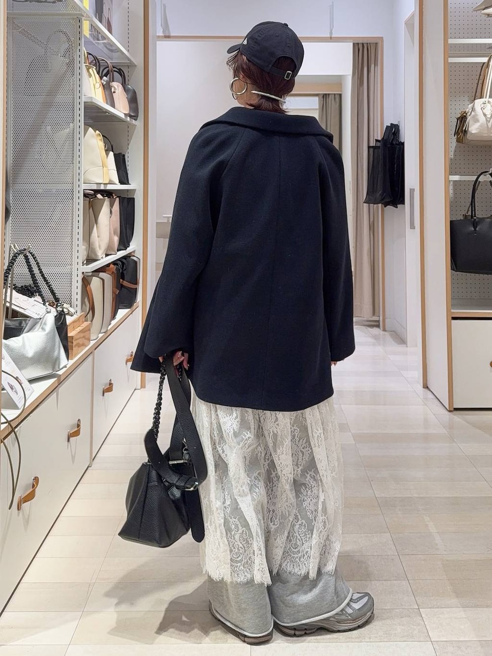 ブルー系のチェスターコート、グレー系のワンピース、ブルー系のスウェットを着用したレディースの冬コーディネートの7枚目の写真