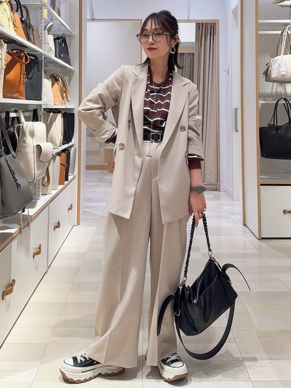 グレー系のワンピース、ベージュ系のテーラードジャケット、ゴールド系のネックレスを着用したレディースの冬コーディネートの5枚目の写真