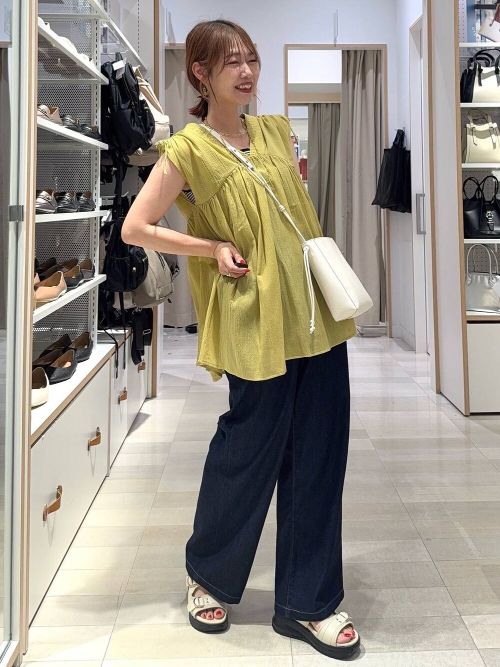 ホワイト系のタンクトップ、グレー系のスカート、イエロー系のシャツ/ブラウスを着用したレディースの夏コーディネートの2枚目の写真