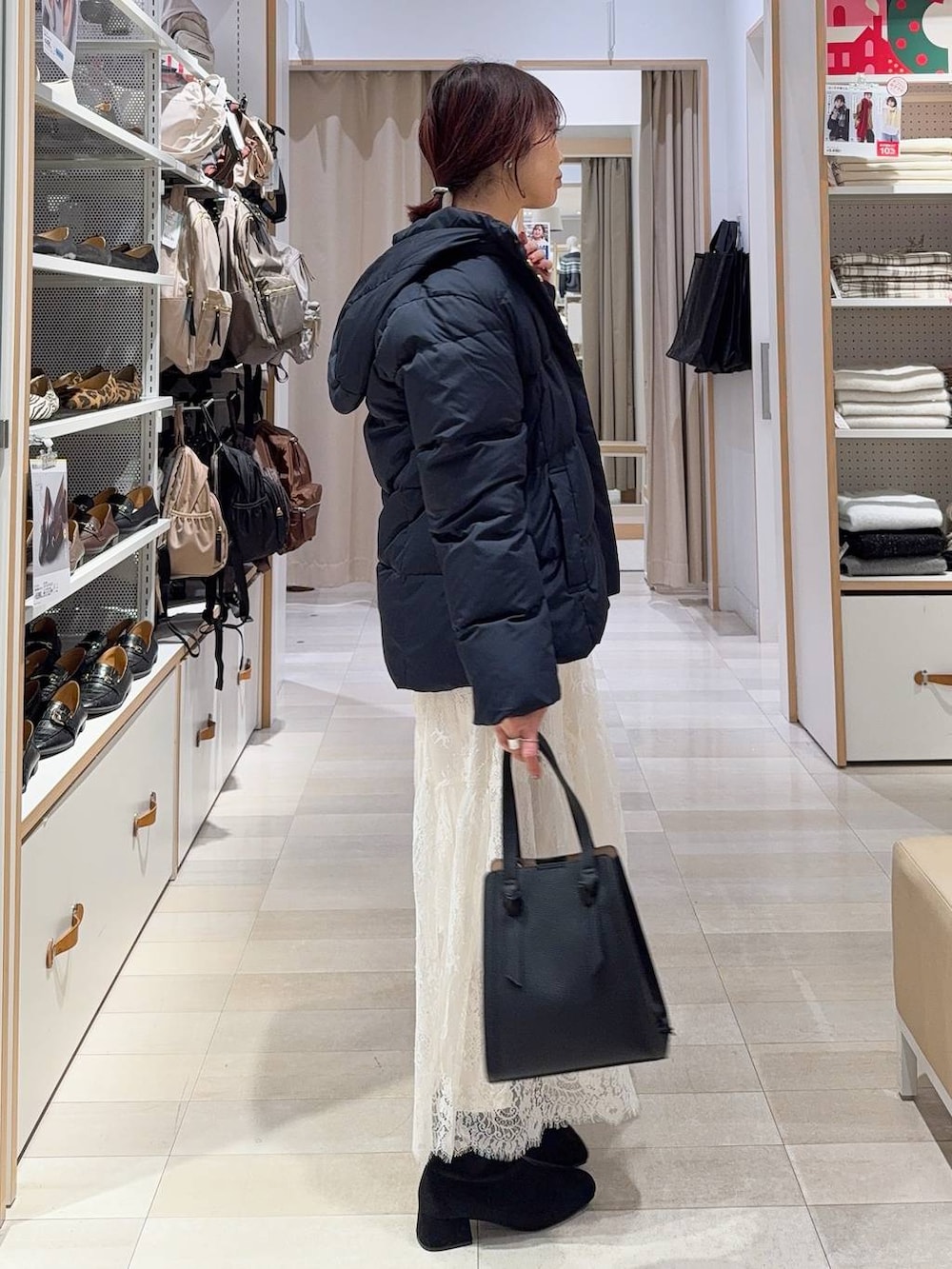 ブラック系のショルダーバッグ、ブルー系のダウンジャケット/コート、グレー系のワンピースを着用したレディースの冬コーディネートの5枚目の写真