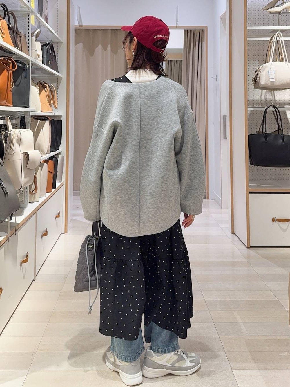 ホワイト系のスニーカー、ブルー系のデニムパンツ、ホワイト系のニット/セーターを着用したレディースの冬コーディネートの5枚目の写真