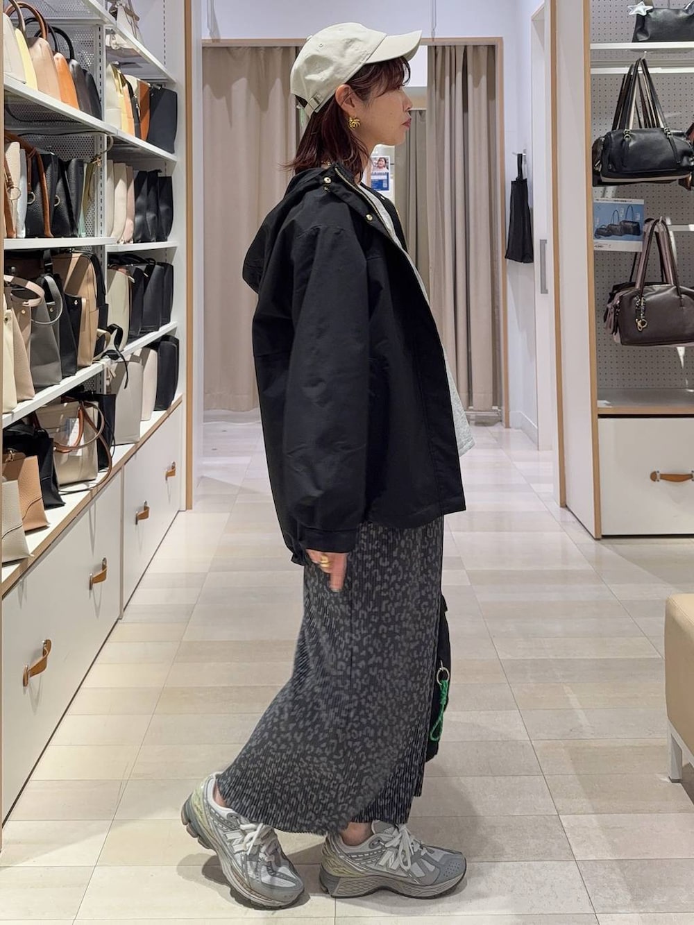 ブラック系のトートバッグ、ブラック系のマウンテンパーカー、グレー系のスカートを着用したレディースの春コーディネートの4枚目の写真