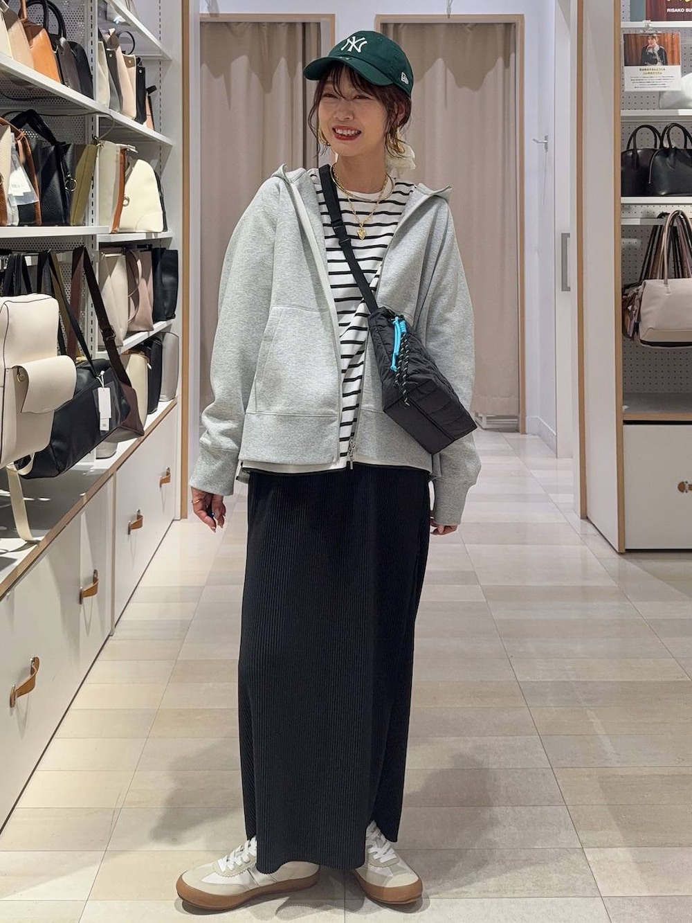 ホワイト系のスニーカー、ブラウン系のボストンバッグ、グレー系のパーカーを着用したレディースの春コーディネートの3枚目の写真