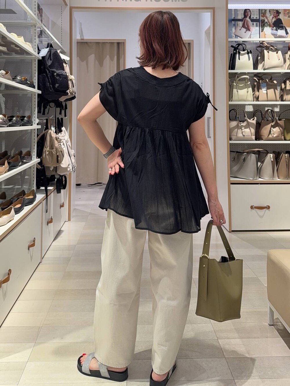 ホワイト系のデニムパンツ、グリーン系のショルダーバッグ、ブラック系のシャツ/ブラウスを着用したレディースの夏コーディネートの7枚目の写真