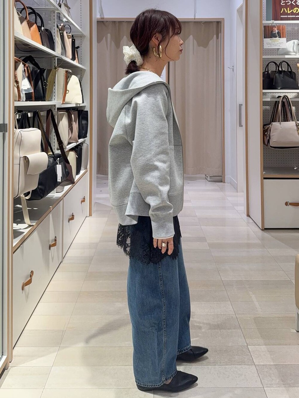 ブラック系のパンプス、グレー系のパーカー、ブルー系のデニムパンツを着用したレディースの冬コーディネートの7枚目の写真