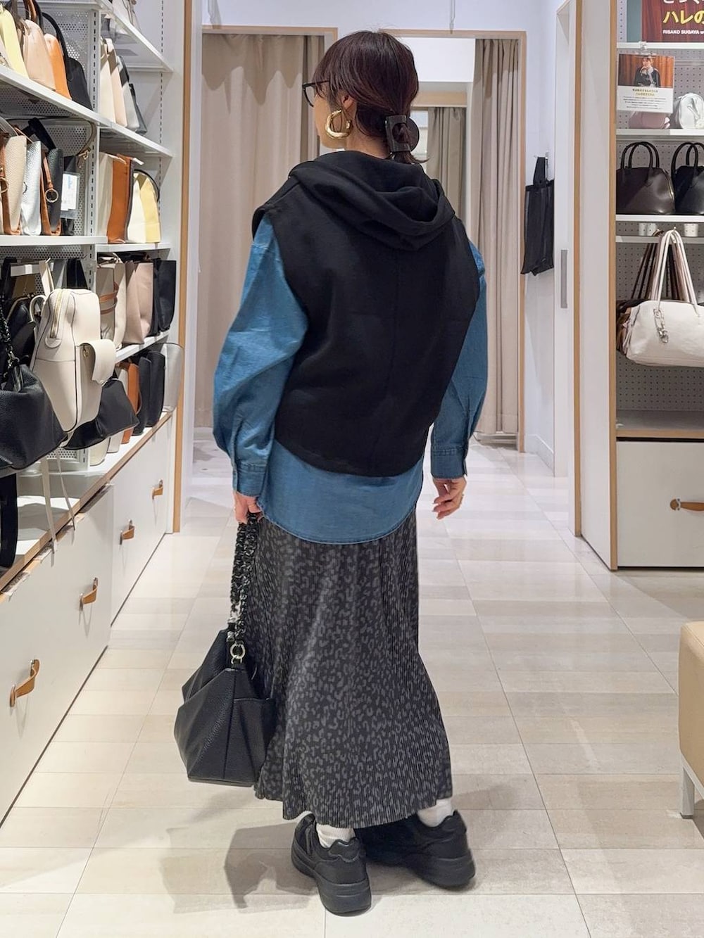 ブラック系のスニーカー、ブルー系のシャツ/ブラウス、ブラック系のベストを着用したレディースの冬コーディネートの5枚目の写真