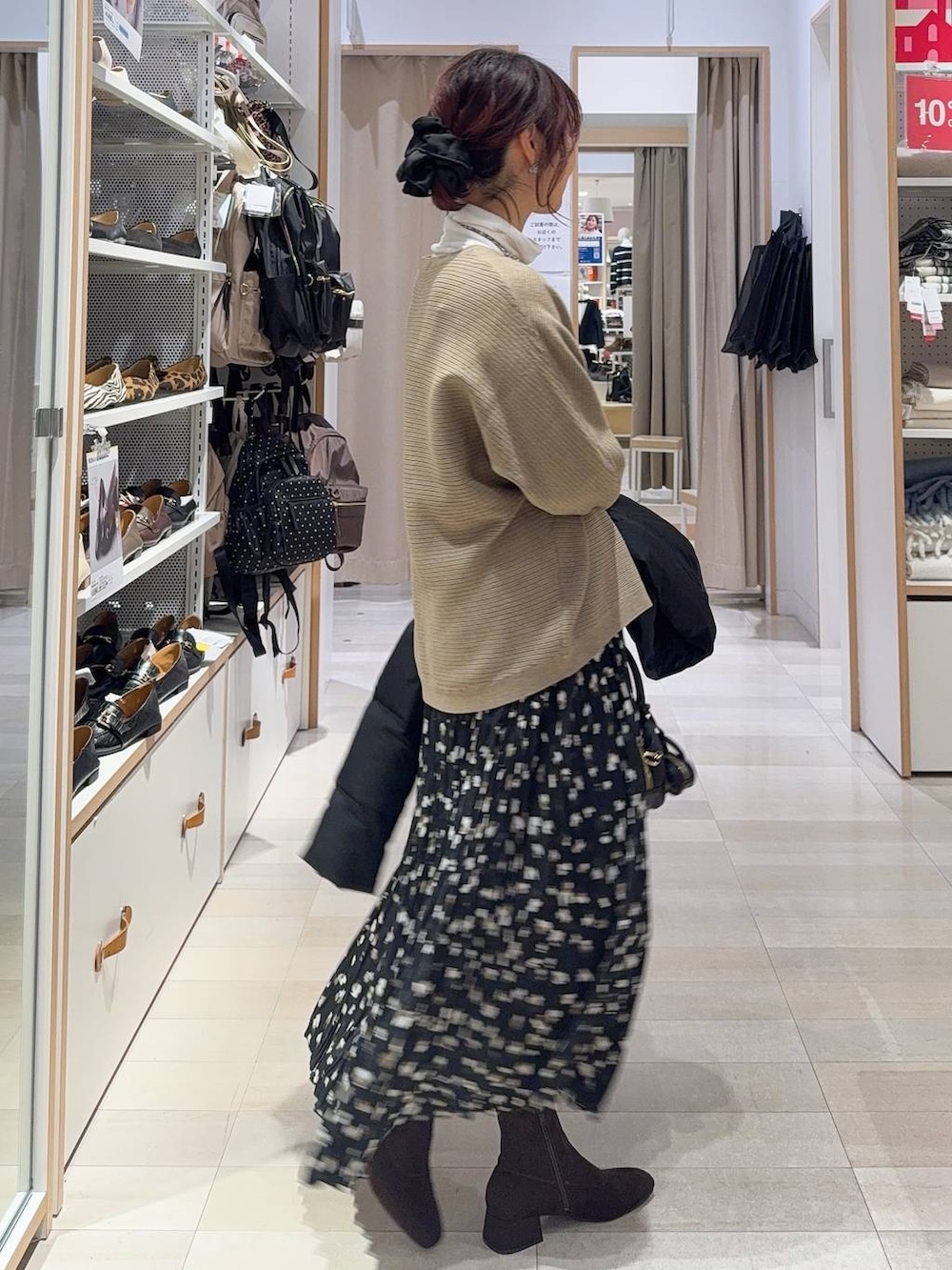 ブラック系のダウンジャケット/コート、ホワイト系のTシャツ/カットソー、ブラウン系のニット/セーターを着用したレディースの冬コーディネートの8枚目の写真