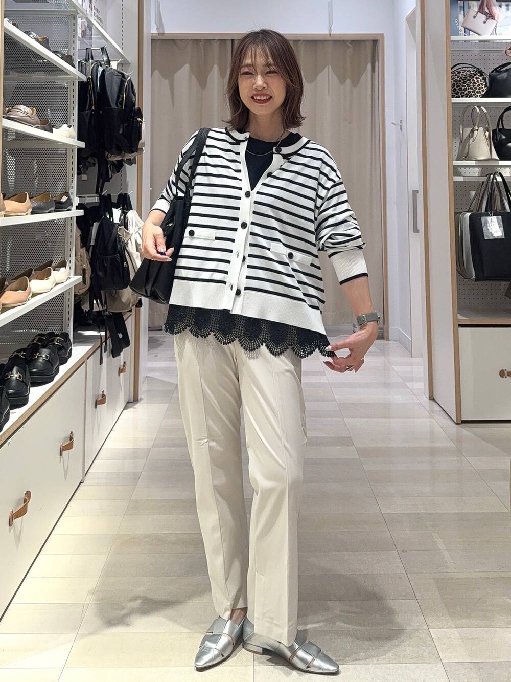 ブラック系のショルダーバッグ、ブルー系のカーディガン/ボレロ、グレー系のパンプスを着用したレディースの夏コーディネートの2枚目の写真