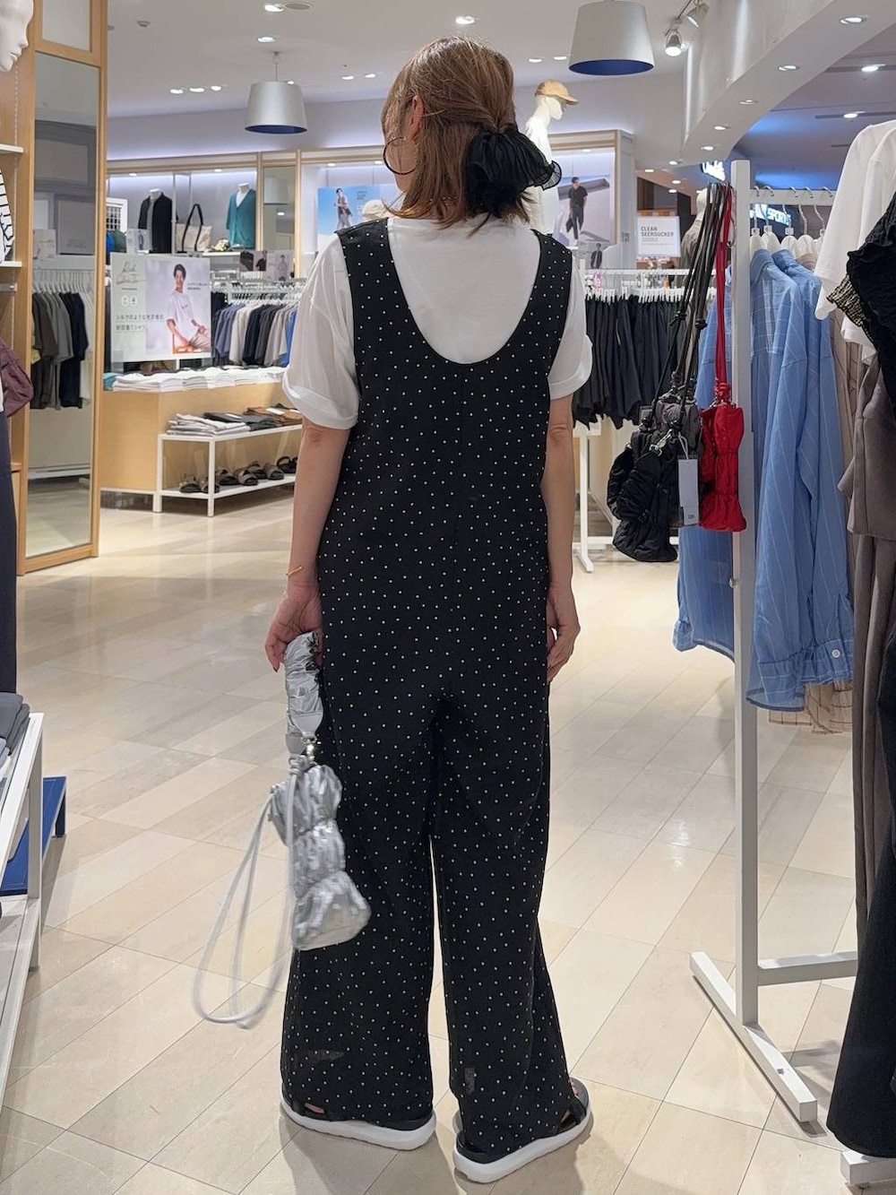 ブラック系のサロペット/オーバーオール、ホワイト系のTシャツ/カットソー、ブラック系のサンダルを着用したレディースの夏コーディネートの5枚目の写真