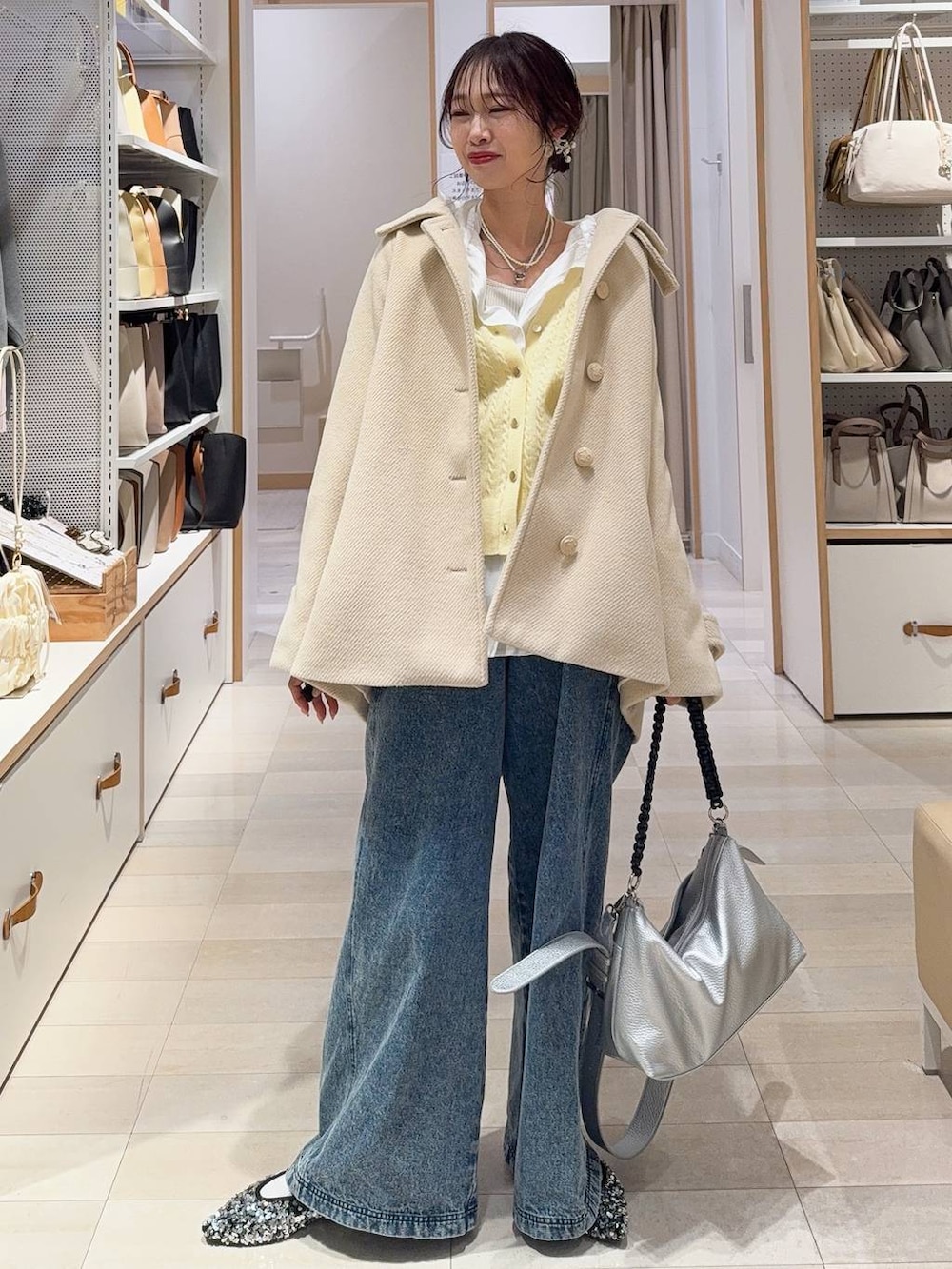 ホワイト系のシャツ/ブラウス、ホワイト系のステンカラーコート、イエロー系のカーディガン/ボレロを着用したレディースの冬コーディネートの2枚目の写真