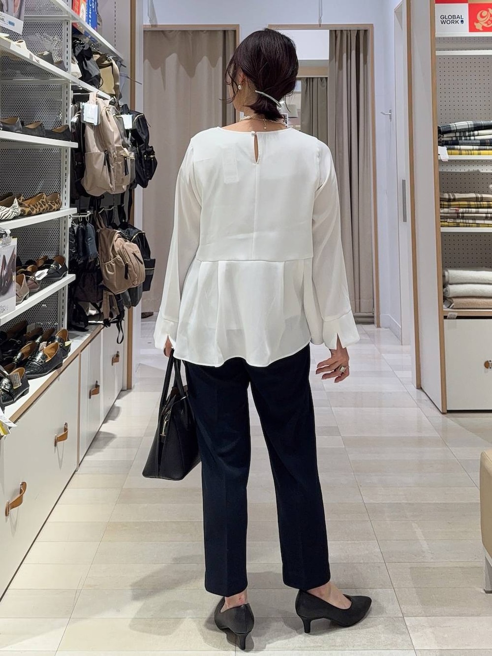 ブラック系のショルダーバッグ、ブラック系のパンプス、ブルー系のセットアップを着用したレディースの冬コーディネートの8枚目の写真