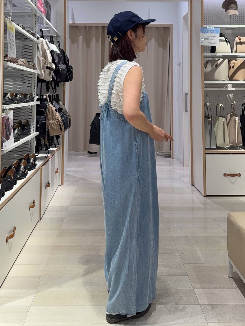 ブラック系のスニーカー、ブラック系のショルダーバッグ、ホワイト系のTシャツ/カットソーを着用したレディースの秋コーディネートの6枚目の写真