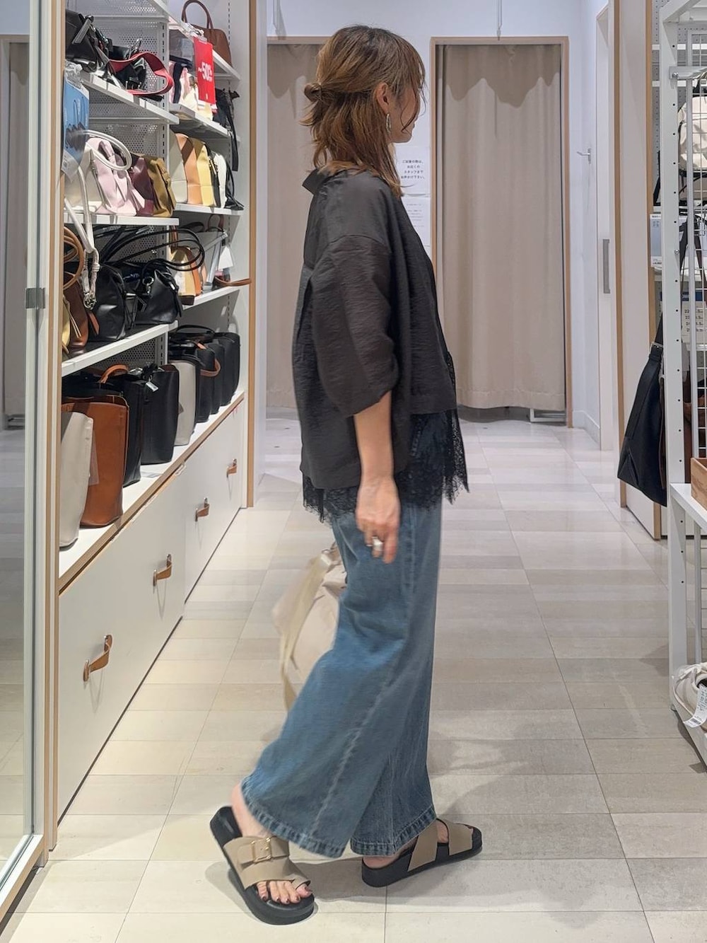 ブルー系のデニムパンツ、グレー系のシャツ/ブラウス、ベージュ系のサンダルを着用したレディースの夏コーディネートの4枚目の写真