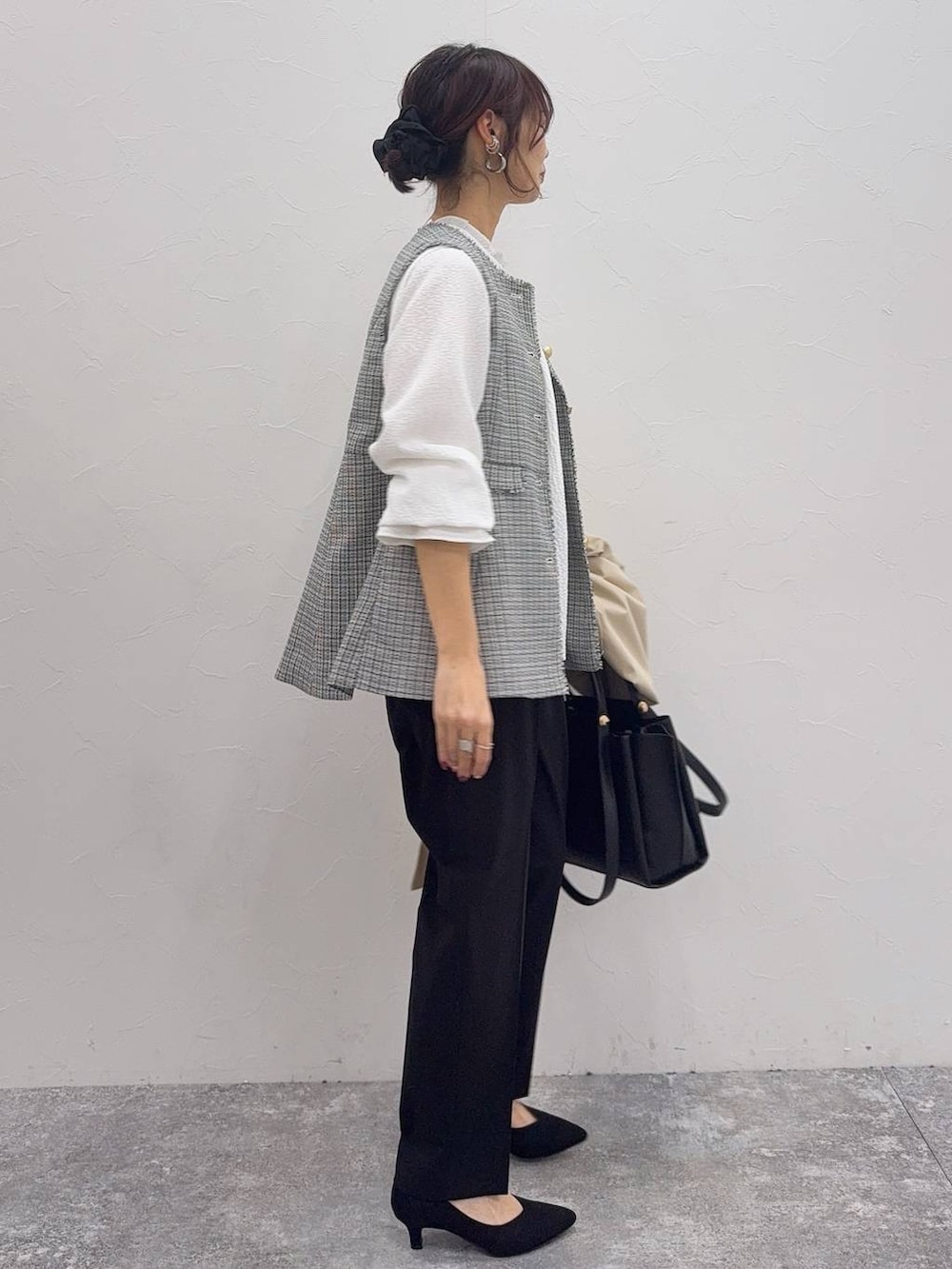 ブラック系のパンプス、ホワイト系のシャツ/ブラウス、ブラック系のスラックスを着用したレディースの冬コーディネートの6枚目の写真