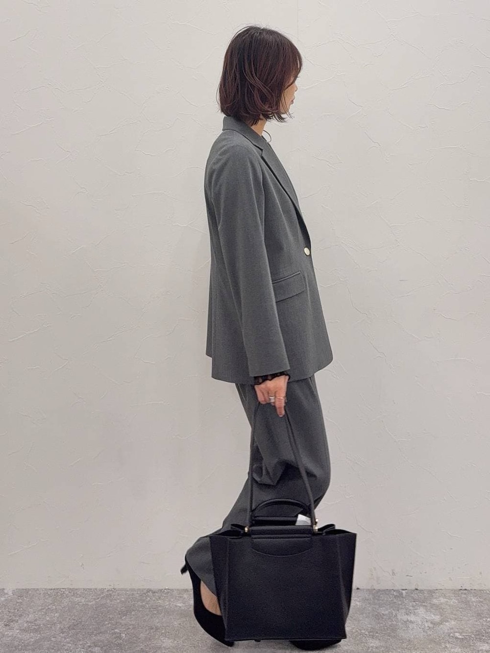 ブラック系のパンプス、ブラック系のキャミソール、ブラック系のTシャツ/カットソーを着用したレディースの冬コーディネートの2枚目の写真