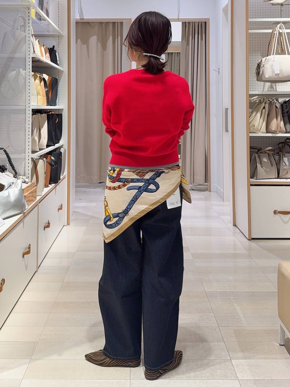 その他のパンプス、ベージュ系のボストンバッグ、ブルー系のデニムパンツを着用したレディースの冬コーディネートの8枚目の写真