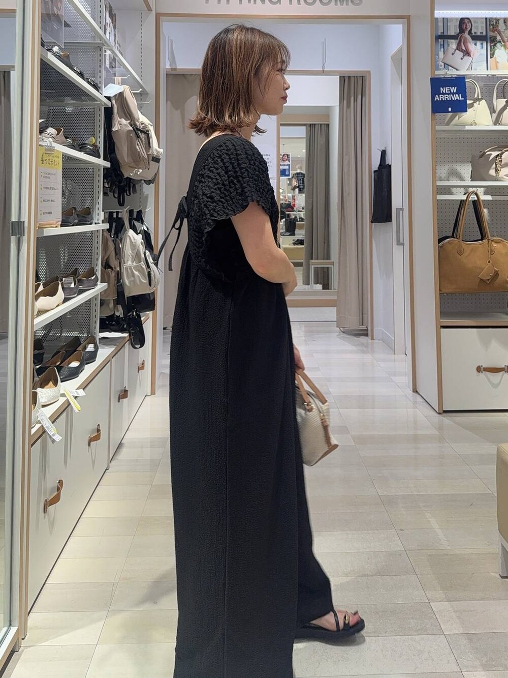 ホワイト系のショルダーバッグ、ブラック系のキャミソール、ブラック系のサンダルを着用したレディースの夏コーディネートの2枚目の写真