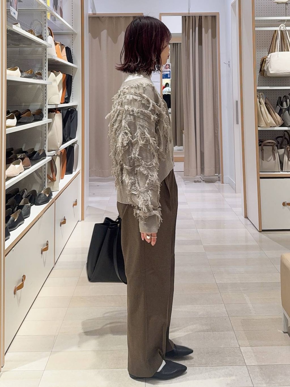 ブラック系のパンプス、ホワイト系のニット/セーター、ブラウン系のその他パンツを着用したレディースの冬コーディネートの5枚目の写真