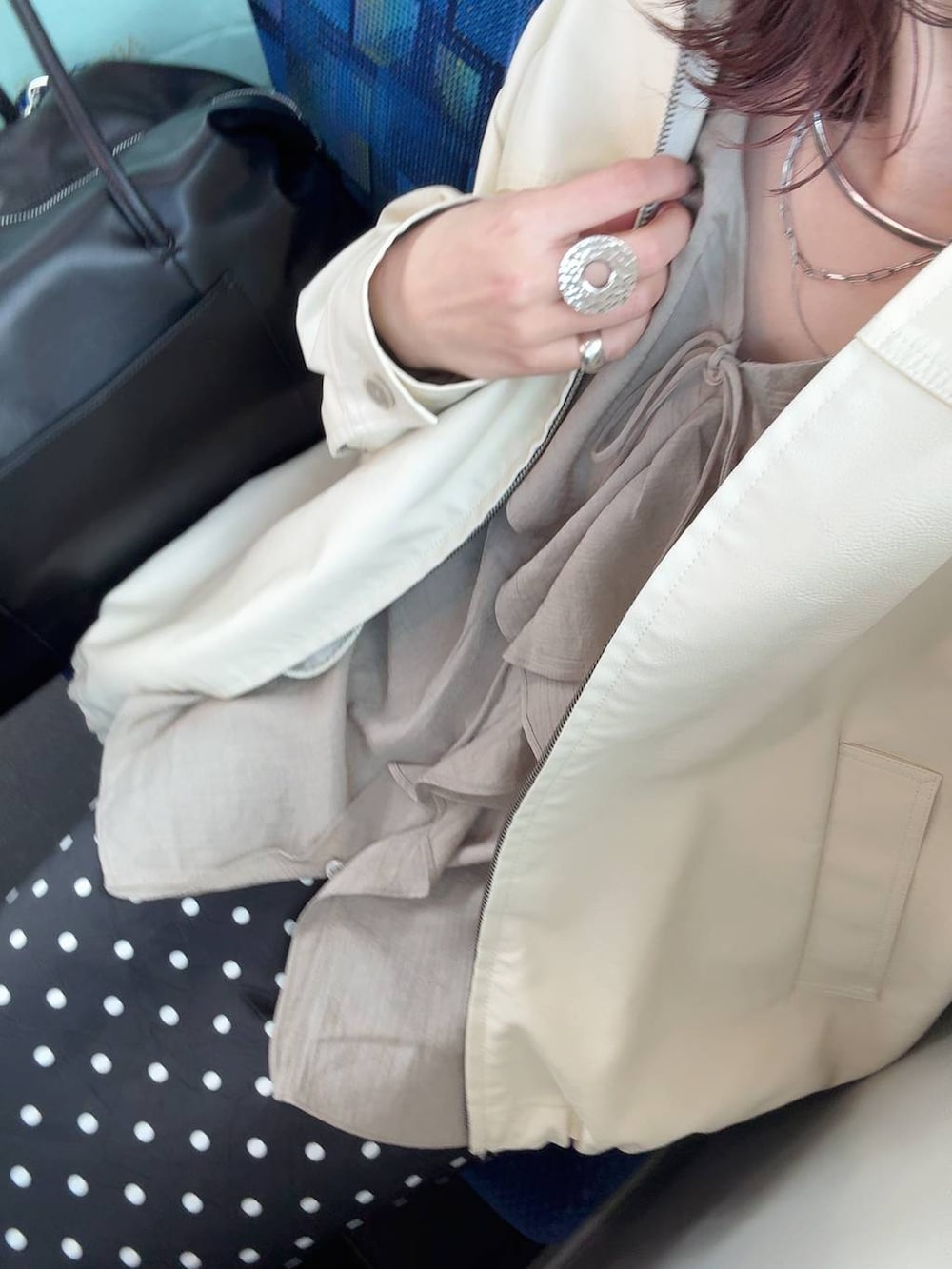 ホワイト系のブルゾン、ブラック系のスカート、ブラック系のボストンバッグを着用したレディースの春コーディネートの4枚目の写真