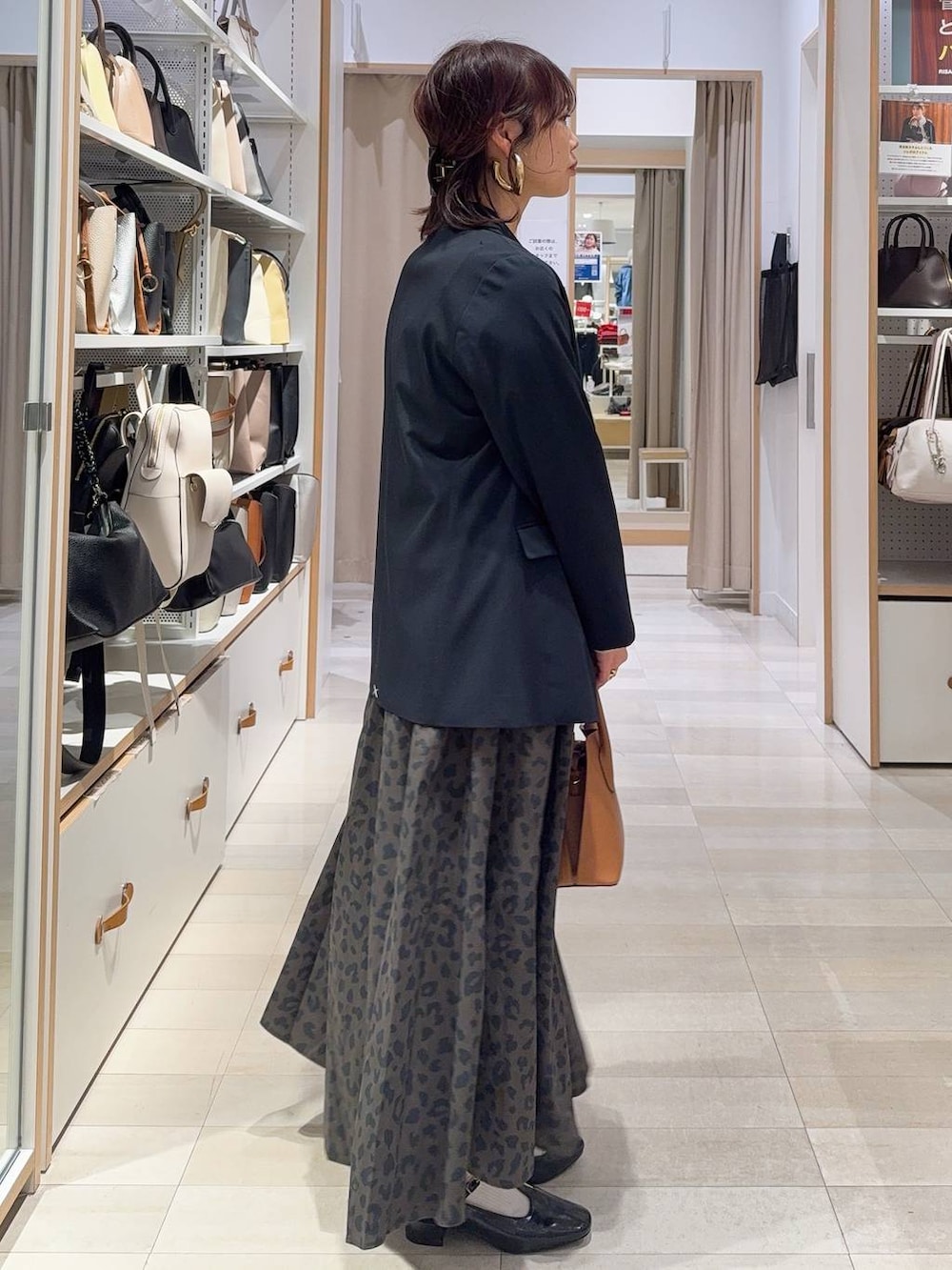 ブラウン系のショルダーバッグ、ブルー系のテーラードジャケット、その他のスカートを着用したレディースの冬コーディネートの5枚目の写真