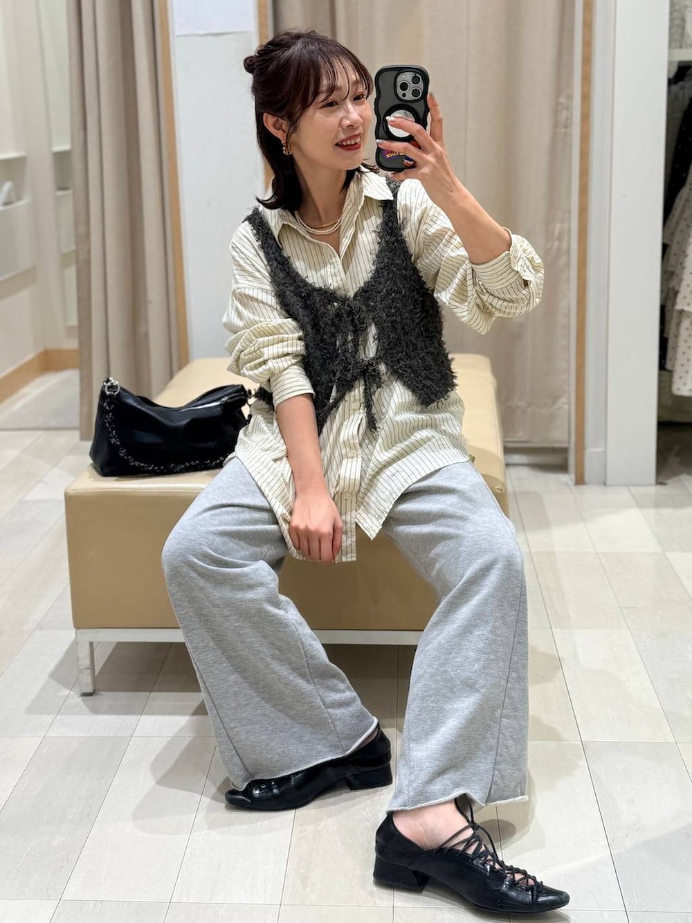 イエロー系のシャツ/ブラウス、グレー系のスウェットパンツ、グレー系のベストを着用したレディースの春コーディネートの2枚目の写真