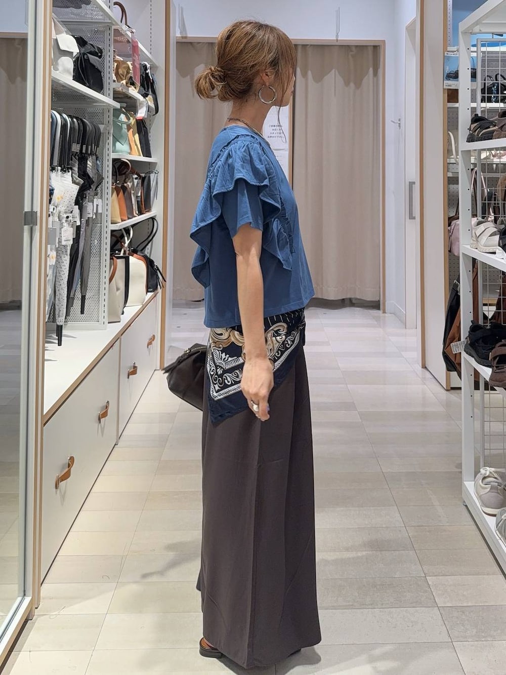 ブラウン系のその他パンツ、ブラウン系のボストンバッグ、ブルー系のTシャツ/カットソーを着用したレディースの夏コーディネートの4枚目の写真