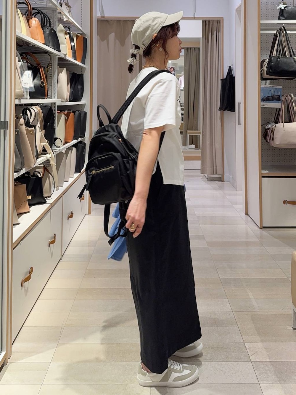 グレー系のスニーカー、ブラック系のバックパック/リュック、ブラック系のスカートを着用したレディースの春コーディネートの6枚目の写真