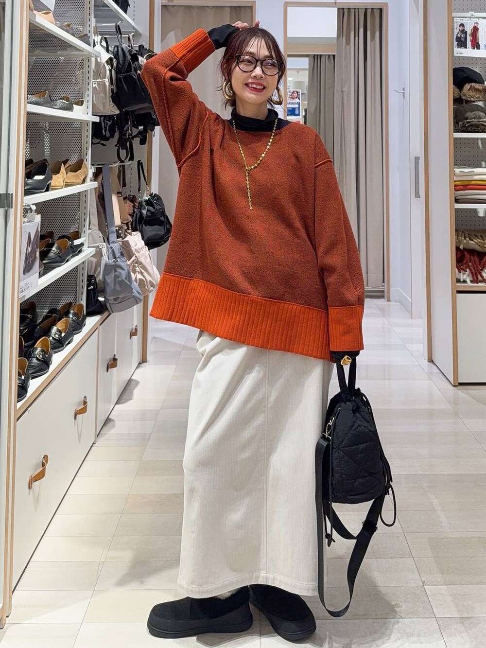 ブラック系のショルダーバッグ、ブルー系のチェスターコート、イエロー系のブーツを着用したレディースの冬コーディネートの9枚目の写真