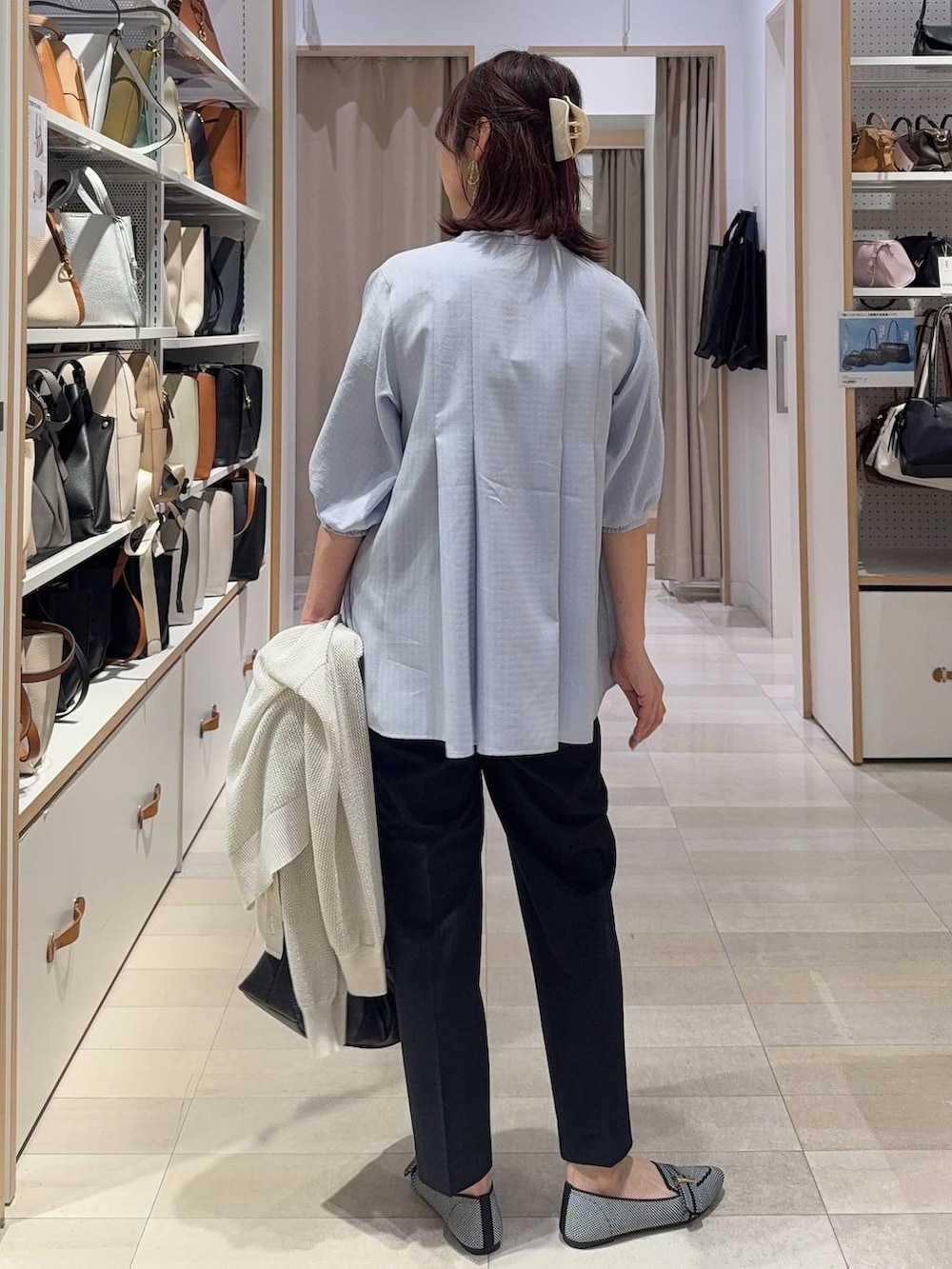 ブラック系のパンプス、ブルー系のスラックス、ホワイト系のカーディガン/ボレロを着用したレディースの春コーディネートの7枚目の写真