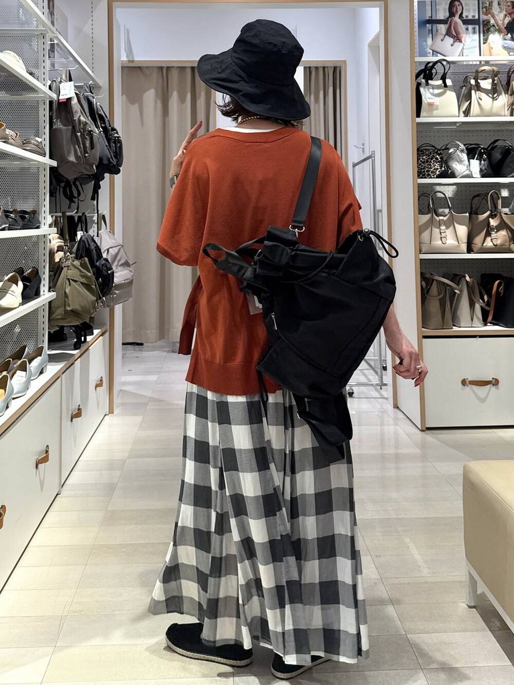 ホワイト系のスカート、ブラック系のスリッポン、オレンジ系のカーディガン/ボレロを着用したレディースの春コーディネートの5枚目の写真