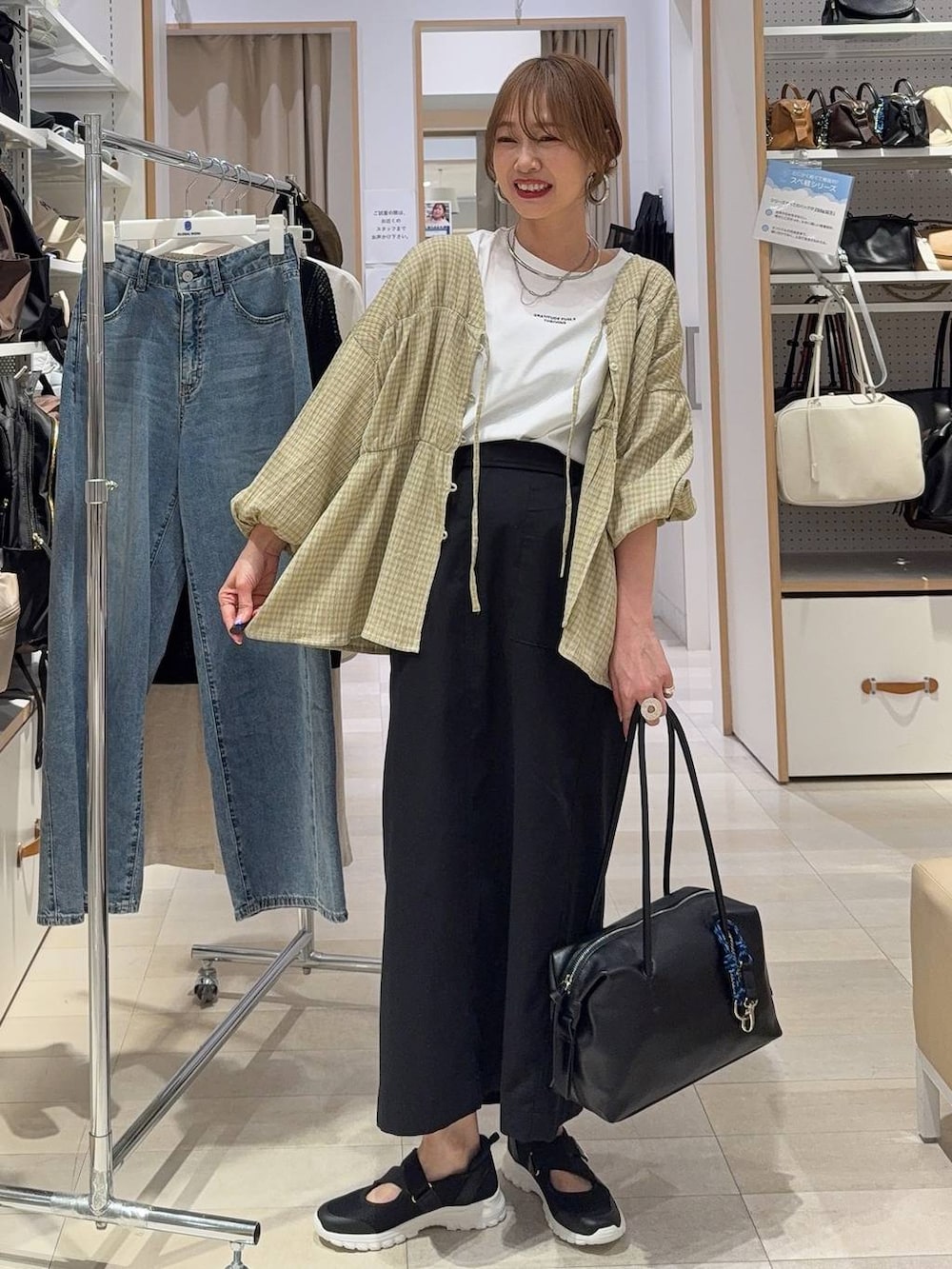 ベージュ系のパンプス、ホワイト系のショルダーバッグ、ホワイト系のキャミソールを着用したレディースの春コーディネートの5枚目の写真
