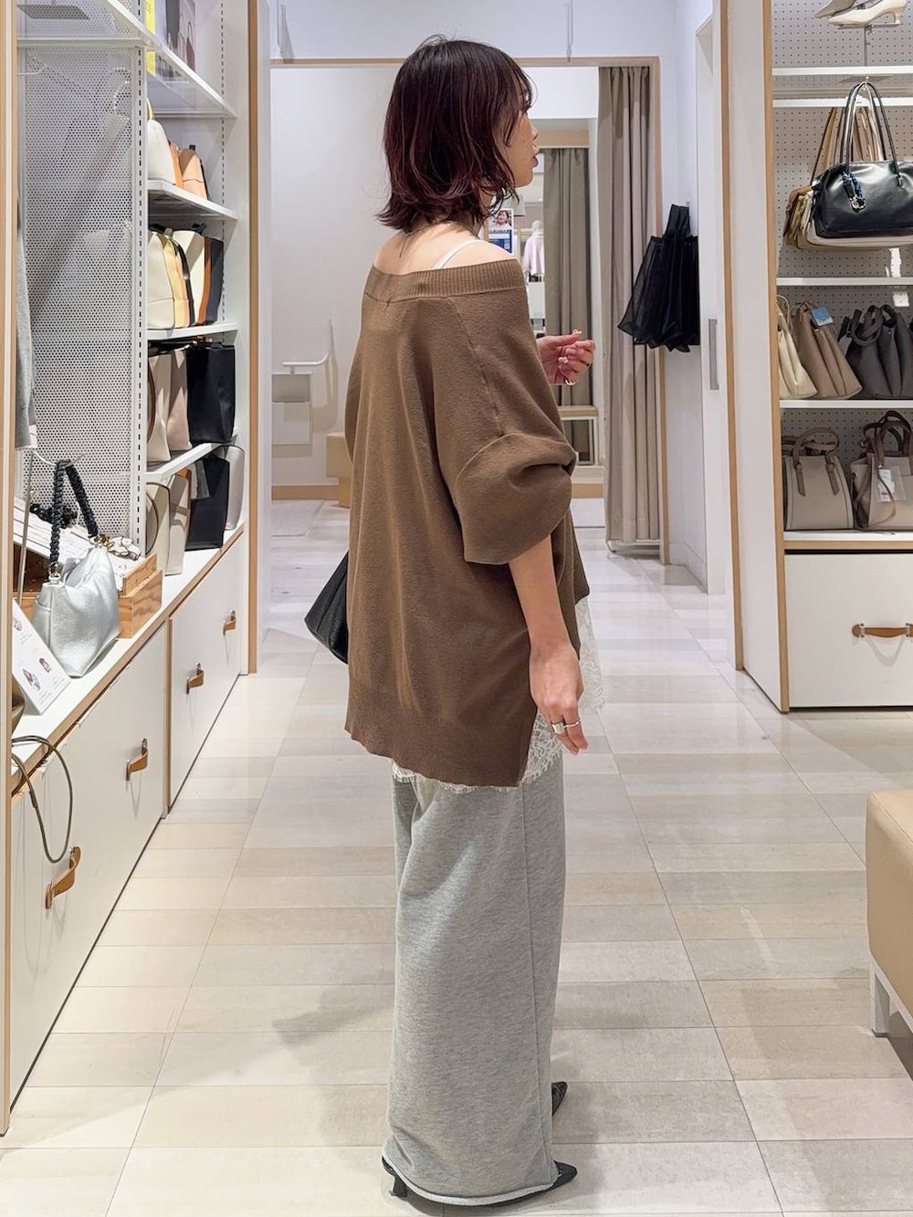 ホワイト系のキャミソール、ブラウン系のニット/セーター、グレー系のスウェットパンツを着用したレディースの冬コーディネートの8枚目の写真