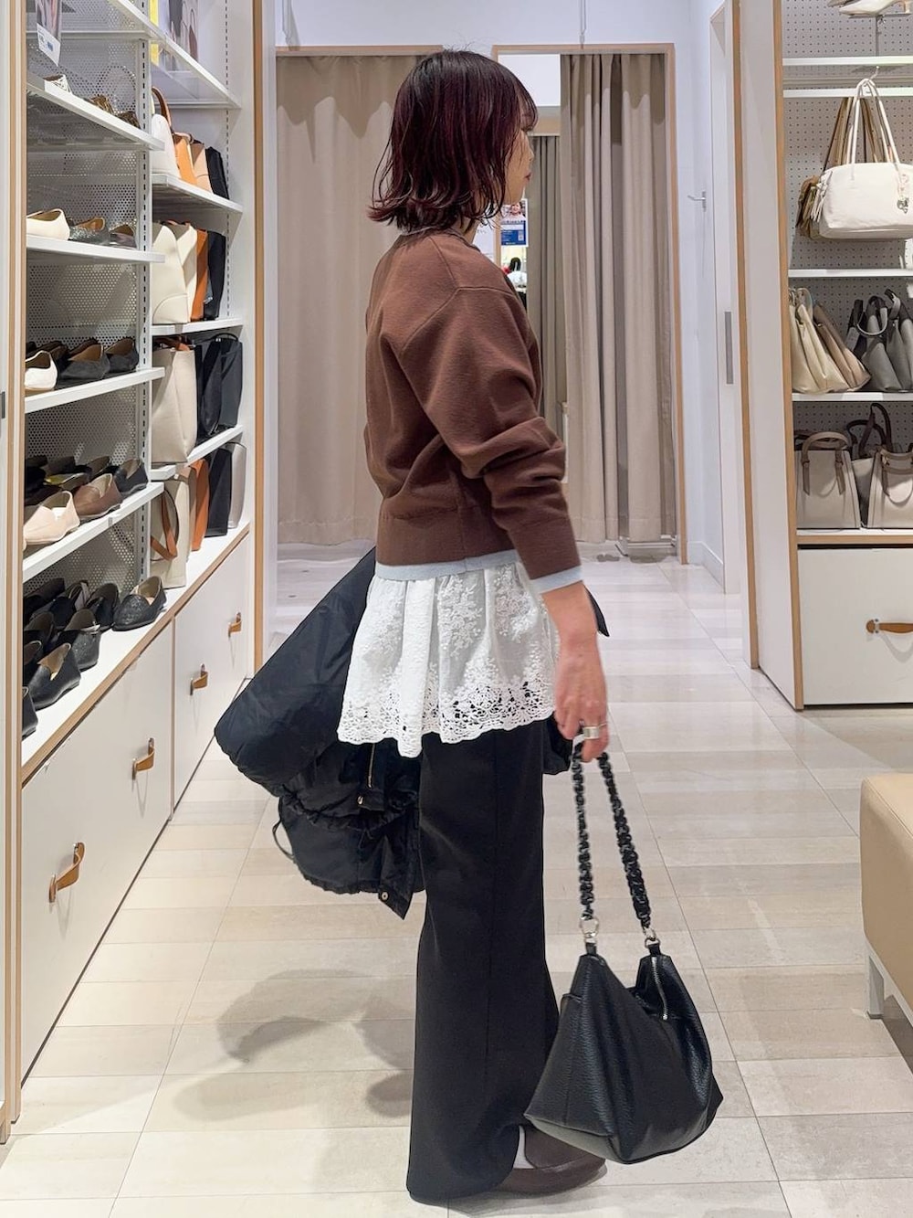 ブルー系のダウンジャケット/コート、ブラウン系のカーディガン/ボレロ、ブラック系のスウェットパンツを着用したレディースの冬コーディネートの5枚目の写真