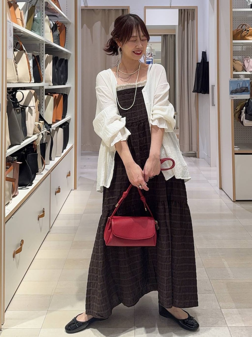 ブラウン系のベスト、ブルー系のデニムパンツ、その他のネックレスを着用したレディースの春コーディネートの6枚目の写真