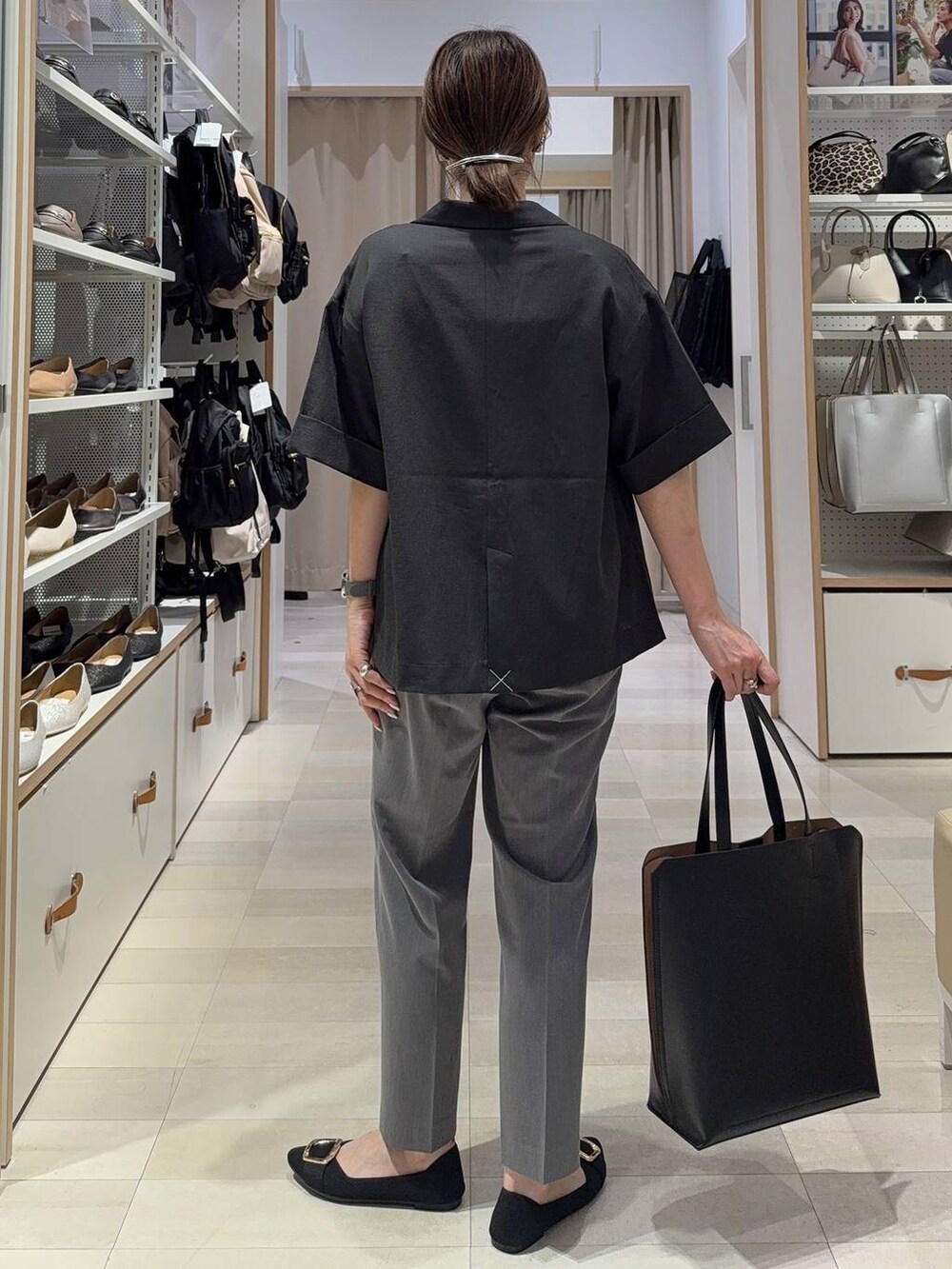 ブラック系のトートバッグ、ブラック系のパンプス、グレー系のその他パンツを着用したレディースの夏コーディネートの6枚目の写真