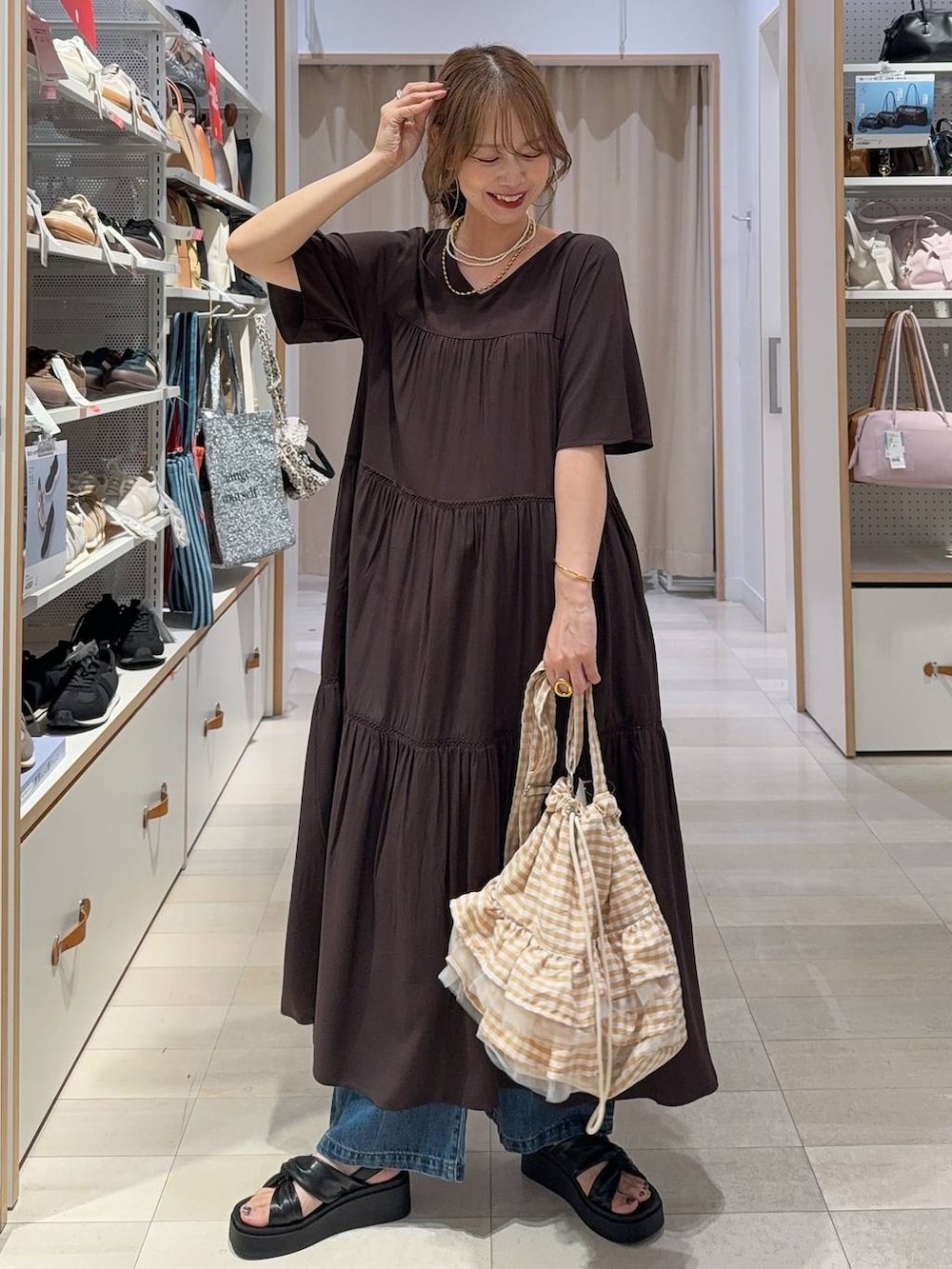 ブルー系のデニムパンツ、ブラウン系のワンピース、ブラック系のサンダルを着用したレディースの夏コーディネートの4枚目の写真